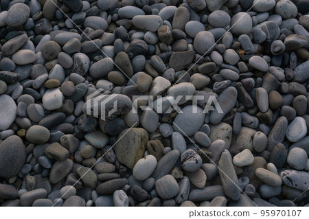 Sea stones background with small pebbles or stone in garden or in the seaside or on a beach. A close up view of rounded smooth polished pebble stones Sea stones background with small pebbles or stone in garden or in the seaside or on a beach. A close up view of rounded smooth polished pebble stones 95970107