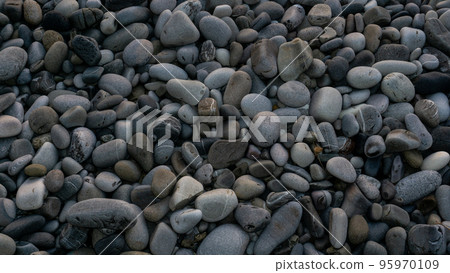 Sea stones background with small pebbles or stone in garden or in the seaside or on a beach. A close up view of rounded smooth polished pebble stones 95970109