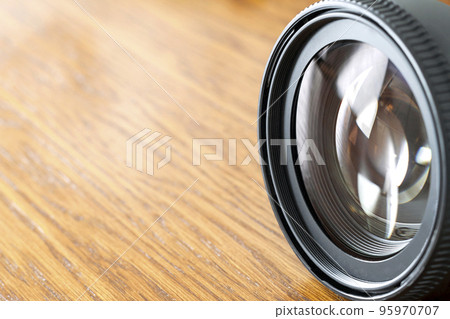 Professional Photography Equipment, Photographer Work Kit. Close-up macro shot of photo camera objective lens on wooden table. Shallow DOF 95970707