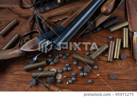 Antique 16-gauge break-action smooth-bored shotgun with brass cases and accessories for cartridge reloading. Antique 16-gauge break-action smooth-bored shotgun with brass cases and accessories for cartridge reloading. 95971275