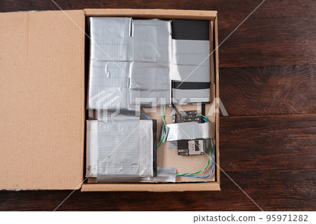 Hand made bomb with c4 and cell phone module in a cardboard box Hand made bomb with c4 and cell phone module in a cardboard box 95971282