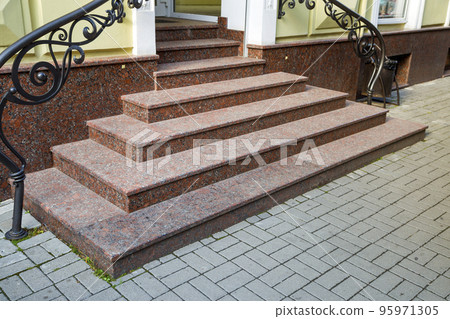 Detail of a house facade. New granite stairs with metal railings. 95971305