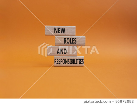 New roles and responsibilities symbol. Wooden blocks with words New roles and responsibilities. Beautiful orangebackground. Business and New roles and responsibilities concept. Copy space. 95972098
