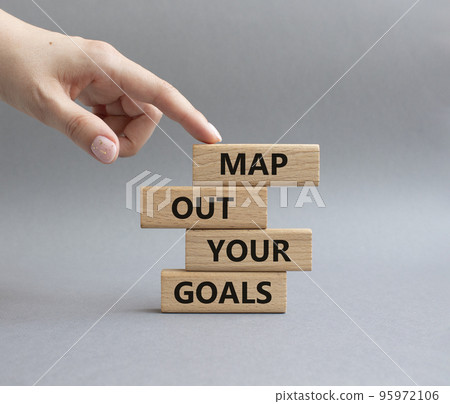 Goals symbol. Wooden blocks with words Map out your goals. Beautiful grey background. Businessman hand. Business and 'Map out your goals' concept. Copy space. Goals symbol. Wooden blocks with words Map out your goals. Beautiful grey background. Businessman hand. Business and 'Map out your goals' concept. Copy space. 95972106