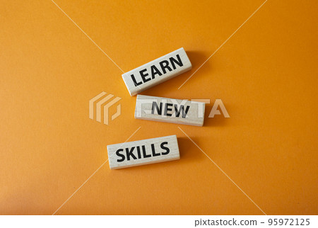 Learn new skills symbol. Concept words Learn new skills on wooden blocks. Beautiful orange background. Business and Learn new skills concept. Copy space. 95972125
