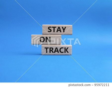 Stay on track symbol. Wooden blocks with words 'Stay on track'. Beautiful blue background. Business and 'Stay on track' concept. Copy space. Stay on track symbol. Wooden blocks with words 'Stay on track'. Beautiful blue background. Business and 'Stay on track' concept. Copy space. 95972211