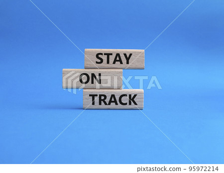 Stay on track symbol. Wooden blocks with words 'Stay on track'. Beautiful blue background. Business and 'Stay on track' concept. Copy space. Stay on track symbol. Wooden blocks with words 'Stay on track'. Beautiful blue background. Business and 'Stay on track' concept. Copy space. 95972214