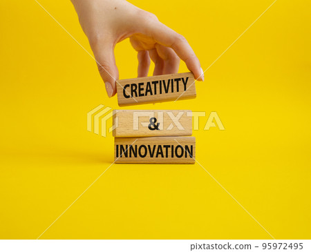 Creativity and innovation symbol. Concept word Creativity and innovation on wooden blocks. Beautiful yellow background. Businessman Hand. Business and Creativity and innovation concept. Copy space 95972495