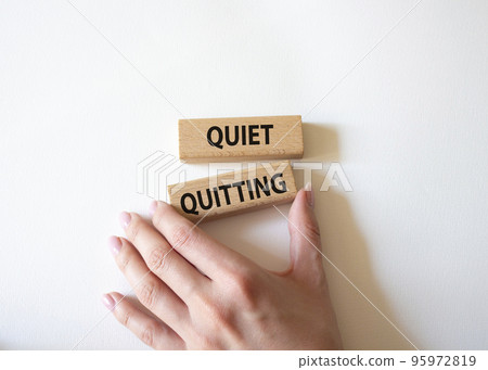 Quiet quitting symbol. Concept word Quiet quitting on wooden blocks. Beautiful white background. Businessman hand. Business and Quiet quitting concept. Copy space. Quiet quitting symbol. Concept word Quiet quitting on wooden blocks. Beautiful white background. Businessman hand. Business and Quiet quitting concept. Copy space. 95972819