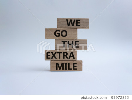 We go the extra mile symbol. Wooden blocks with words 'We go the extra mile'. Beautiful white background. Business and 'We go the extra mile' concept. Copy space. 95972853