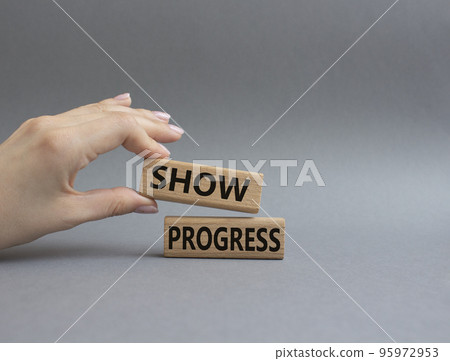 Progress symbol. Wooden blocks with words Show progress. Beautiful grey background. Businessman hand. Business and 'Show progress' concept. Copy space. Progress symbol. Wooden blocks with words Show progress. Beautiful grey background. Businessman hand. Business and 'Show progress' concept. Copy space. 95972953
