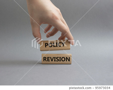 Policy revision symbol. Concept word Policy revision on wooden blocks. Beautiful grey background. Businessman hand. Business and Policy revision concept. Copy space. Policy revision symbol. Concept word Policy revision on wooden blocks. Beautiful grey background. Businessman hand. Business and Policy revision concept. Copy space. 95973034