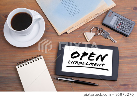 Open Enrollment. Text on tablet device, wooden table Open Enrollment. Text on tablet device, wooden table 95973270
