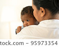 Happy Smiling mother holding adorable newborn baby chubby cheeks 95973354