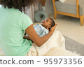 Mother African American holding one-month-old newborn baby gently. 95973356