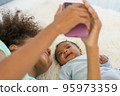 Young mother and newborn baby making video call and smiling greet 95973359