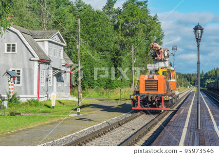 Railcar for the electrical equipment stands by the railway building. Railcar for the electrical equipment stands by the railway building. 95973546