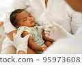 Close up hand of Doctor holding syringe to vaccinate newborn baby 95973608