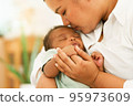 Newborn baby one-month-old holding fingers mother's hand. 95973609