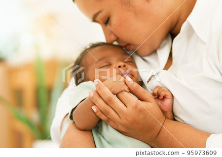 Newborn baby one-month-old holding fingers mother's hand. Newborn baby one-month-old holding fingers mother's hand. 95973609