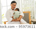 Newborn baby one-month-old sleeping on the warm mother's chest. 95973611