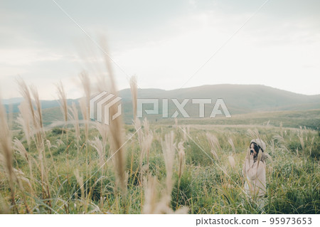 Photo of a woman holding a smartphone in nature 95973653