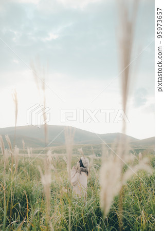 Photo of a woman holding a smartphone in nature Photo of a woman holding a smartphone in nature 95973657