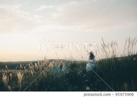 日落時在大自然中讀書的女人的照片 95973906