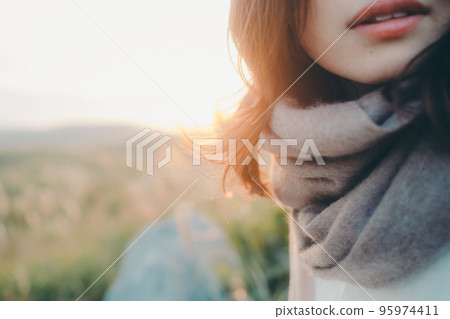 Photo of a woman standing in nature at sunset Photo of a woman standing in nature at sunset 95974411