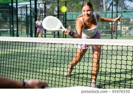 Young woman padel tennis player trains on the outdoor court 95976530