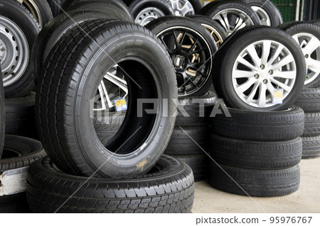 Set of new modern tires in shop. Sale a tire in shop in the background. Set of new modern tires in shop. Sale a tire in shop in the background. 95976767