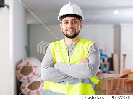 Portrait of a builder standing on a construction site Portrait of a builder standing on a construction site 95977058