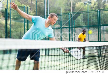 Man in sportswear playing padel tennis match 95977109