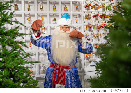 Russian Santa Claus chooses decorations for the Christmas tree in the store. 95977323