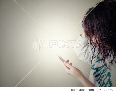 A woman who is worried while looking at her smartphone A woman who is worried while looking at her smartphone 95979879