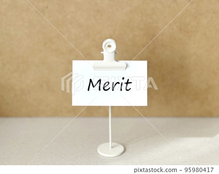 Clip stand and white paper with Merit letters_cork background 95980417