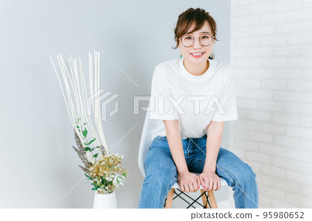 戴眼鏡的日本女人坐在房間的椅子上 95980652
