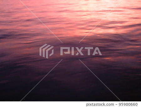 一種景觀材料，其中紅紫色的蒼白日落反射在海面上 95980660