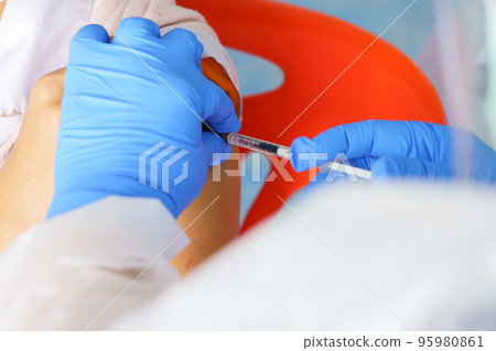 Nurse holding a syringe for the injection giving patient vaccine in hospital. Health care Concept Nurse holding a syringe for the injection giving patient vaccine in hospital. Health care Concept 95980861