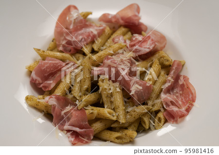 Penne pasta with capocollo, pesto and parmesan cheese Penne pasta with capocollo, pesto and parmesan cheese 95981416