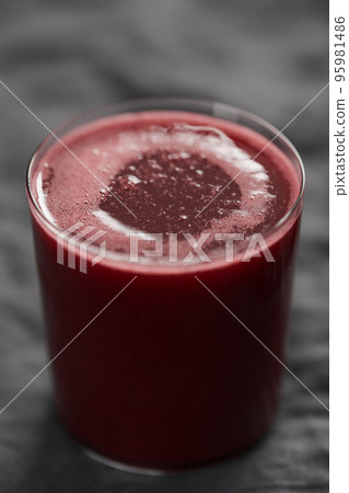 Glass of berry juice on countertop 95981486