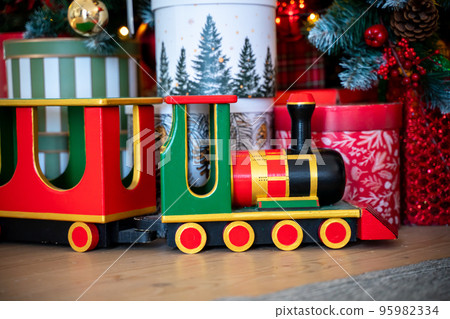 Christmas presents under the Christmas tree. New Year's and Christmas. Wrapped Gift. Beautiful packaging. Ribbon and bow on the packaging. 95982334