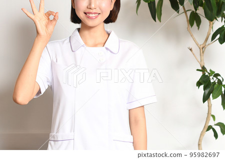 一名女醫務人員在室內給出 OK 的手勢 一名女醫務人員在室內給出 OK 的手勢 95982697