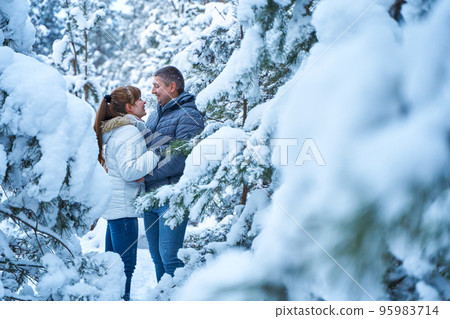 A joyful couple in love walking in winter forest heavy covered with snow 95983714