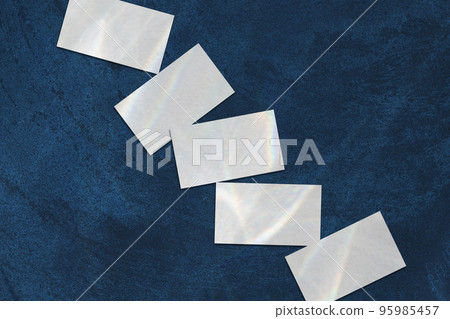 empty white rectangle business card mockups lying diagonally on dark blue concrete background 95985457