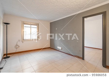 Empty spacious room with window and dirty walls in an old flat before renovation. 95986058
