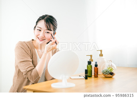 A woman drawing an eye line A woman drawing an eye line 95986315