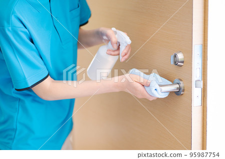 Cleaning staff (young woman, doorknob disinfection) Cleaning staff (young woman, doorknob disinfection) 95987754