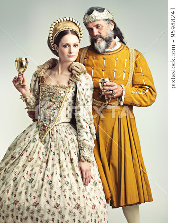 This is how we royals roll. Studio portrait of a king and queen drinking out of goblets. 95988241