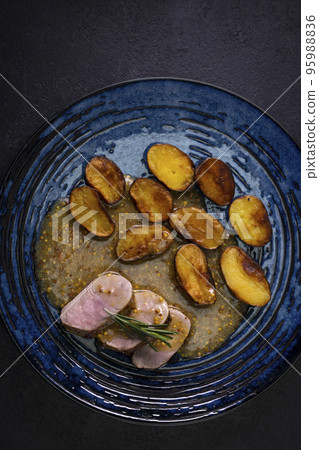 pork tenderloin with baked potatoes and French coarse mustard sauce pork tenderloin with baked potatoes and French coarse mustard sauce 95988836